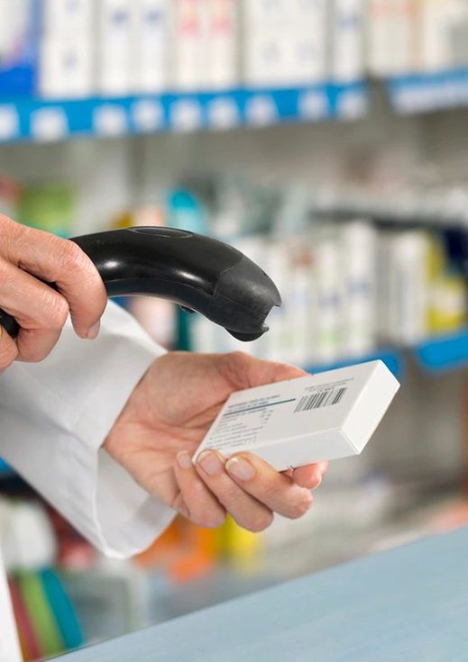 Pharmacist scanning medicine with barcode reader
