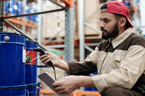 Male Worker Scanning barcode In Warehouse